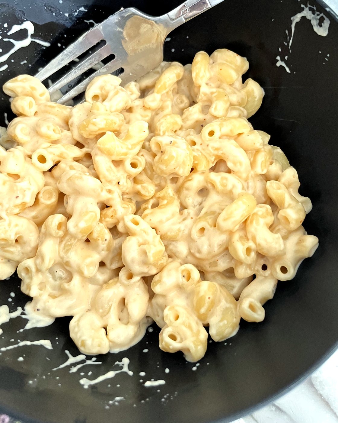 A bowl of creamy Cajun mac and cheese with a fork